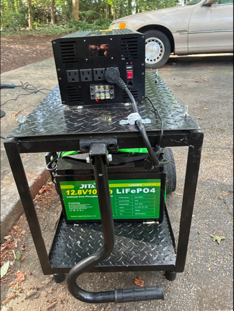 Community-built LiFePO4 generator cart in a steel roll cage with inverter outlet panel